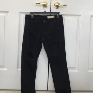 Black jeans with large rips in legs